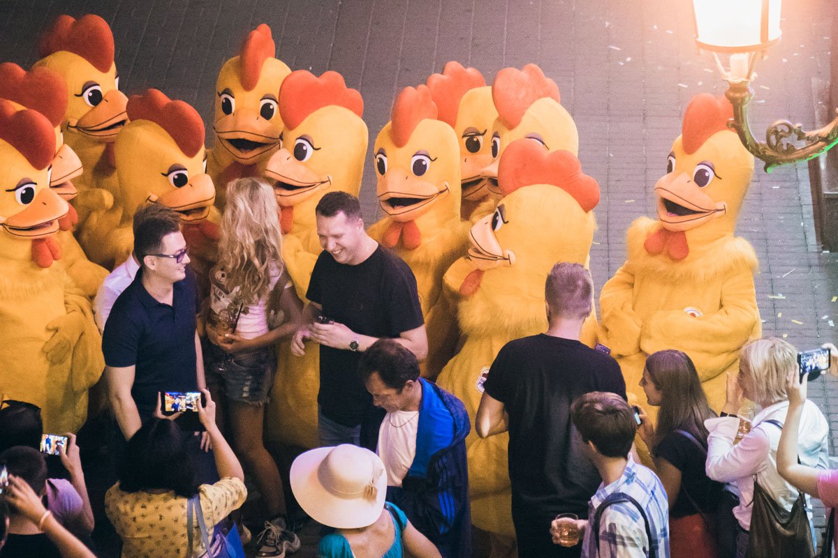 Возле здания "Арена Сити" десятки людей с коктейлями в руках танцевали вместе с аниматорами, переодетыми в костюмы куриц