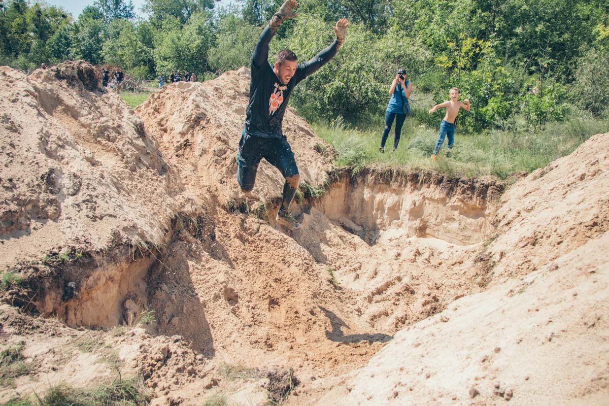 Спортсмены преодолевали ямы с песком, перепрыгивая препятствия Спортсмены преодолевали ямы с песком, перепрыгивая препятствия