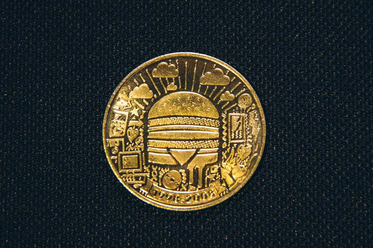 2000-е на монетке изобразили в виде дисков, мобильных  телефонов и компьютеров, которые рассказывают о бурном развитии технологий