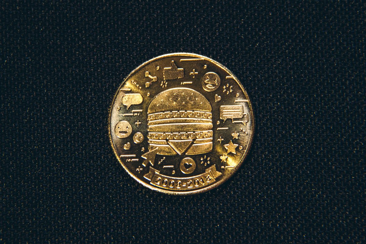 На MacCoin 2010-х поместили значки соцсетей, смайлы и лайки как символы расцвета в сфере коммуникаций.