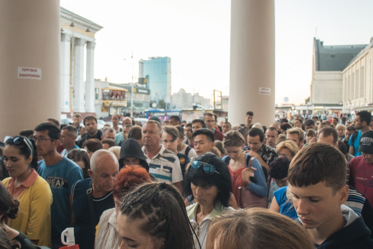 Толпа людей превращается в достаточно организованную очередь, которая тянется от касс аж на улицу Толпа людей превращается в достаточно организованную очередь, которая тянется от касс аж на улицу