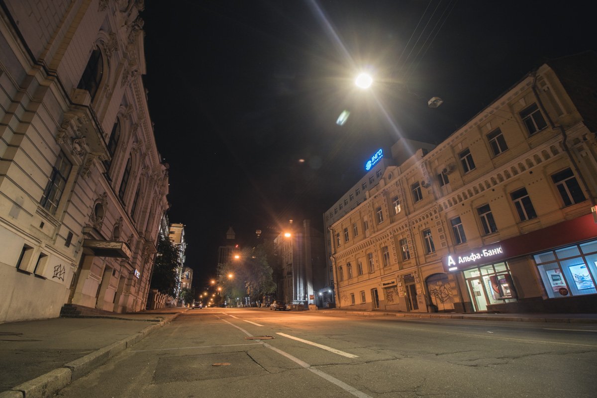 Опустевшая ночная дорога в свете уличных фонарей Опустевшая ночная дорога в свете уличных фонарей