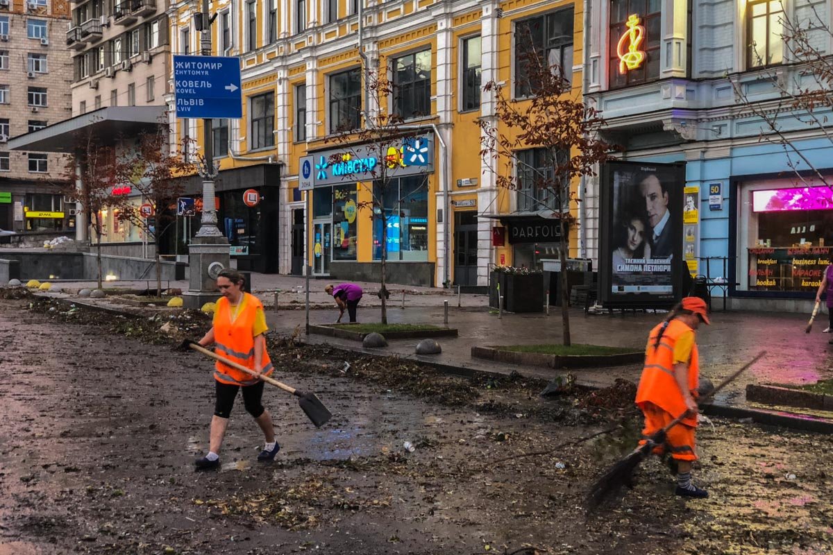 Лопатами убирают ветки, а потом смывают грязь, которую намыло стоками воды