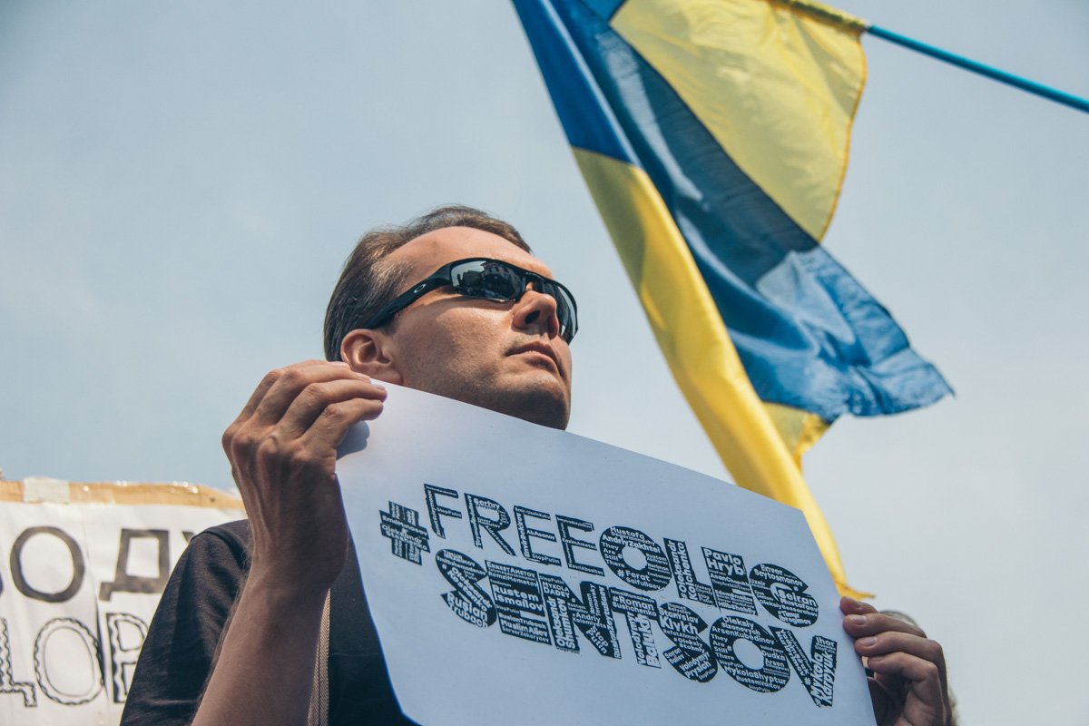 Люди держали плакаты и фотографии в поддержку Сенцова