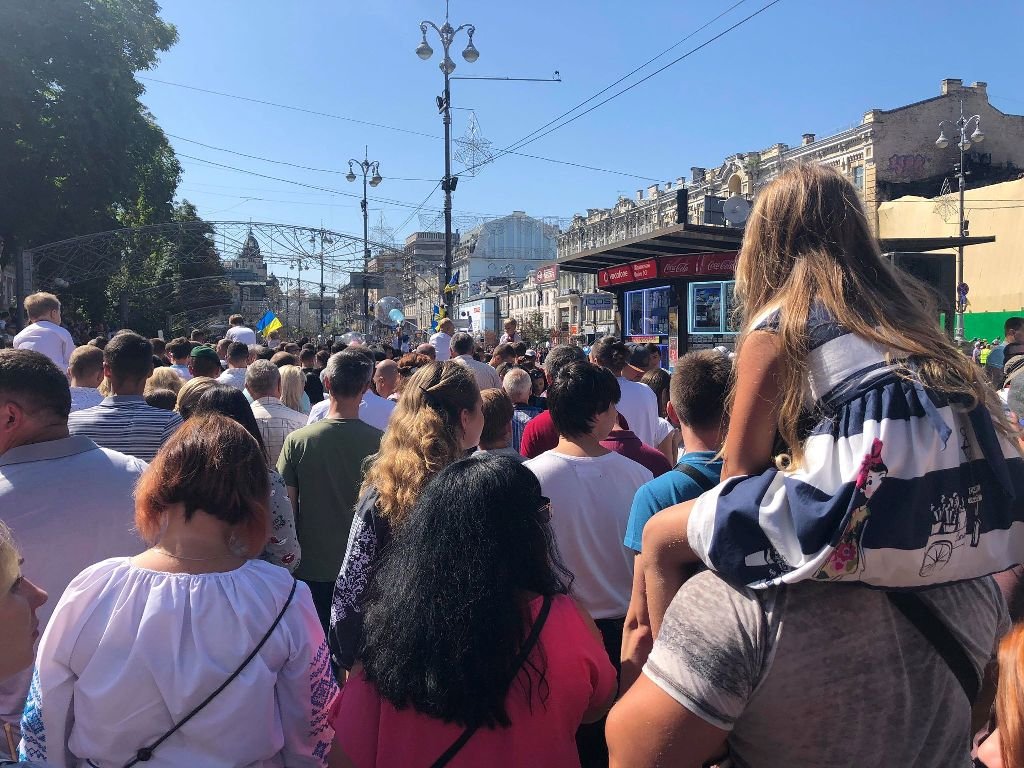 Детей несут на руках и плечах