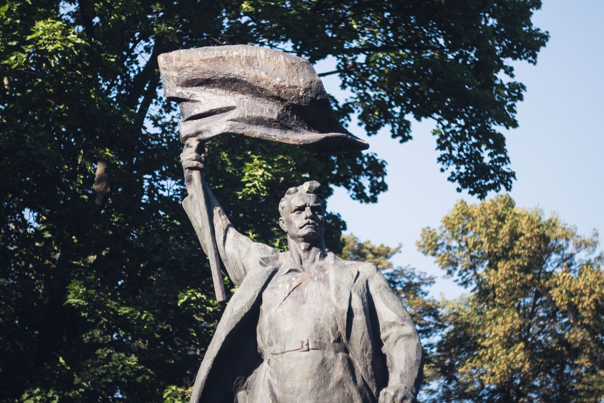 Исторический бронзовый монумент рабочего с развевающимся знаменем