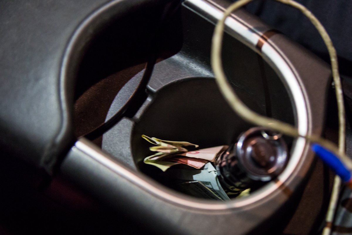 Водитель KIA подбросил три денежные купюры в подстаканник патрульной машины