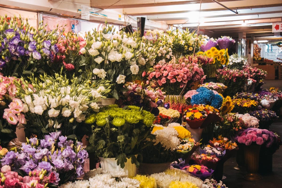 В подземном переходе станции метро "Льва Толстого" продавцы скучающе прогуливаются мимо забитых цветами ваз