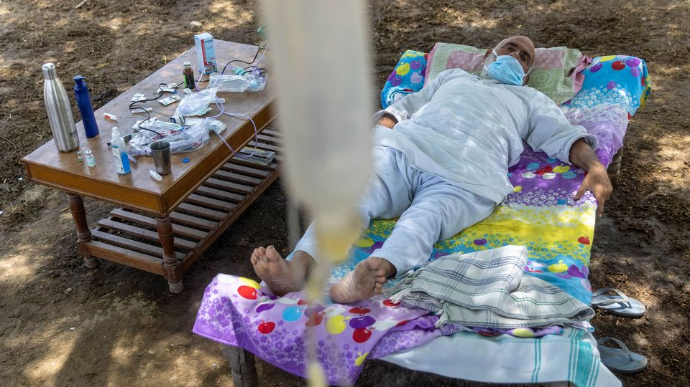 В Индии пациентов с коронавирусом лечат под открытым небом: капельницы висят на деревьях 1