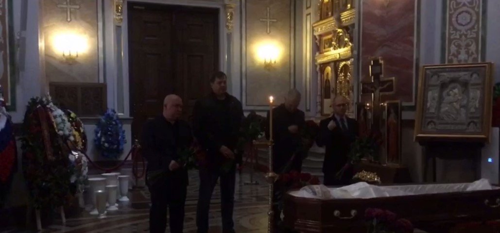 Стремоусов у труні, поруч стоять зрадники Сальдо і Балицький