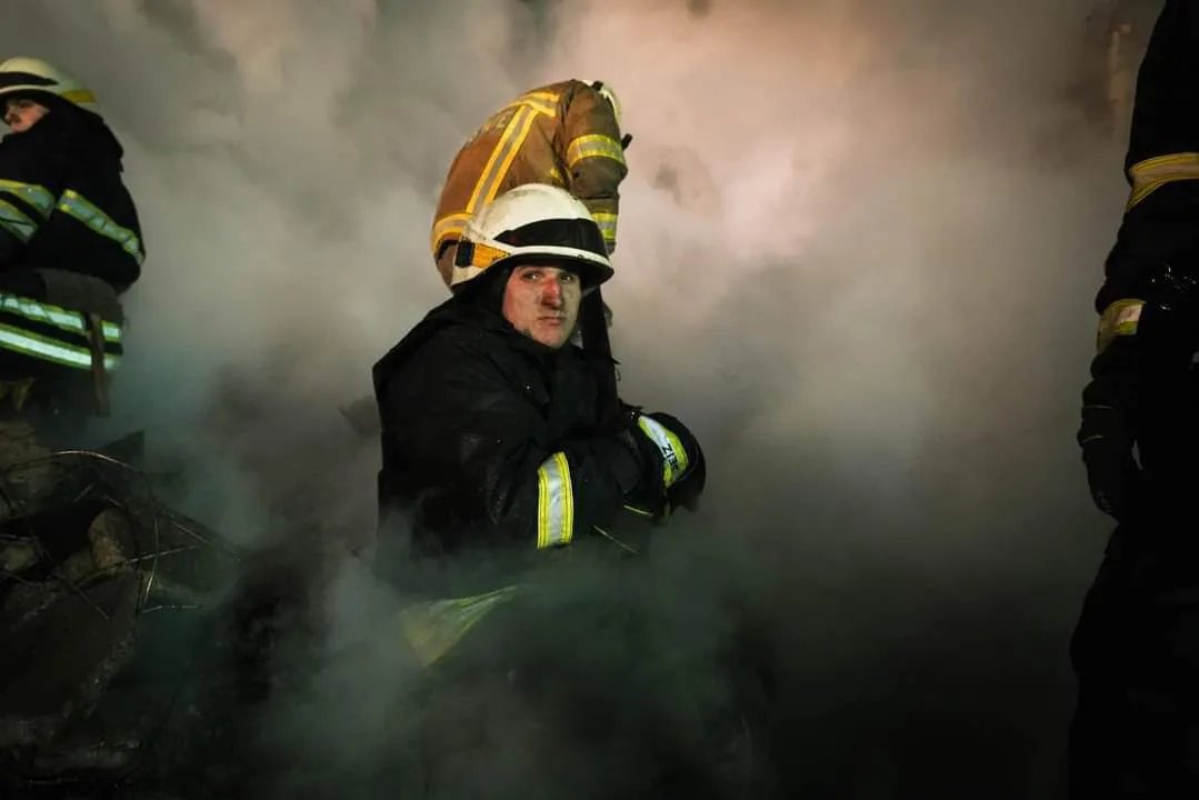 Рятувальник серед пилу, який піднявся на руїнах будинку