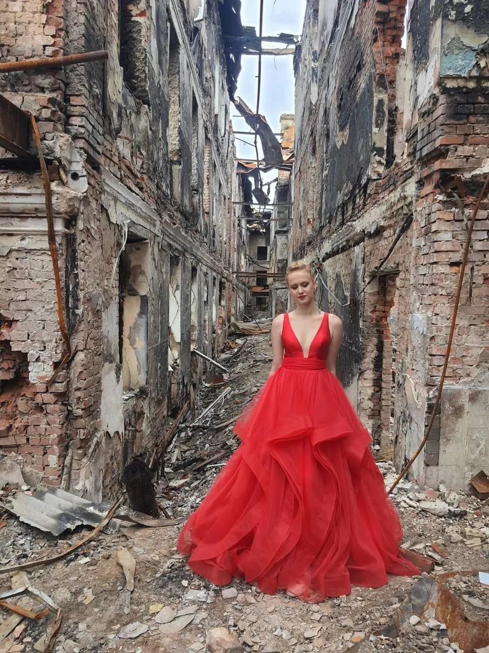 Харківська випускниця фотографується на фоні руїн своєї школи