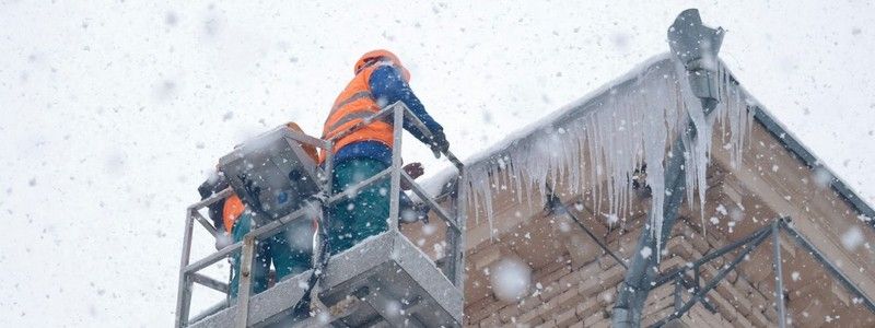 Паркуйся с умом: в центре Днепра коммунальщики сбивают с домов сосульки