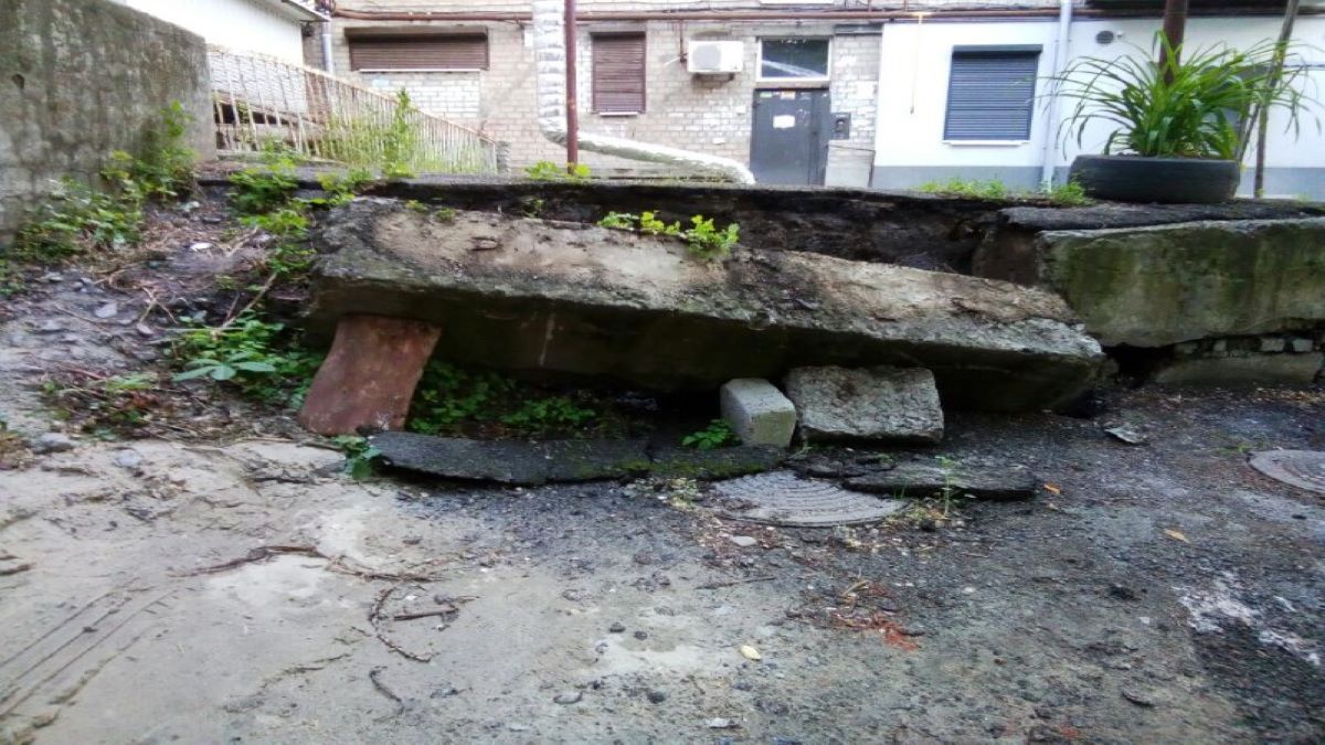 В Днепре возле подъезда дома образовалась дыра: дождевая вода вымывает фундамент