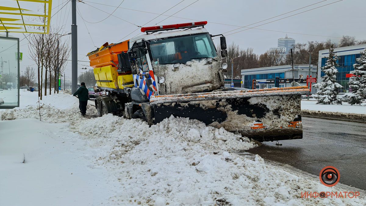 В Днепре на Набережной Победы снегоуборочная машина пробила колеса и застряла на обочине