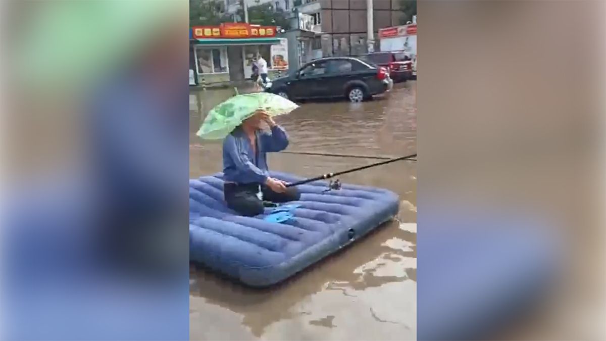 В Днепре мужчина и ребенок плавали на матрасе в огромной луже и ловили в ней рыбу