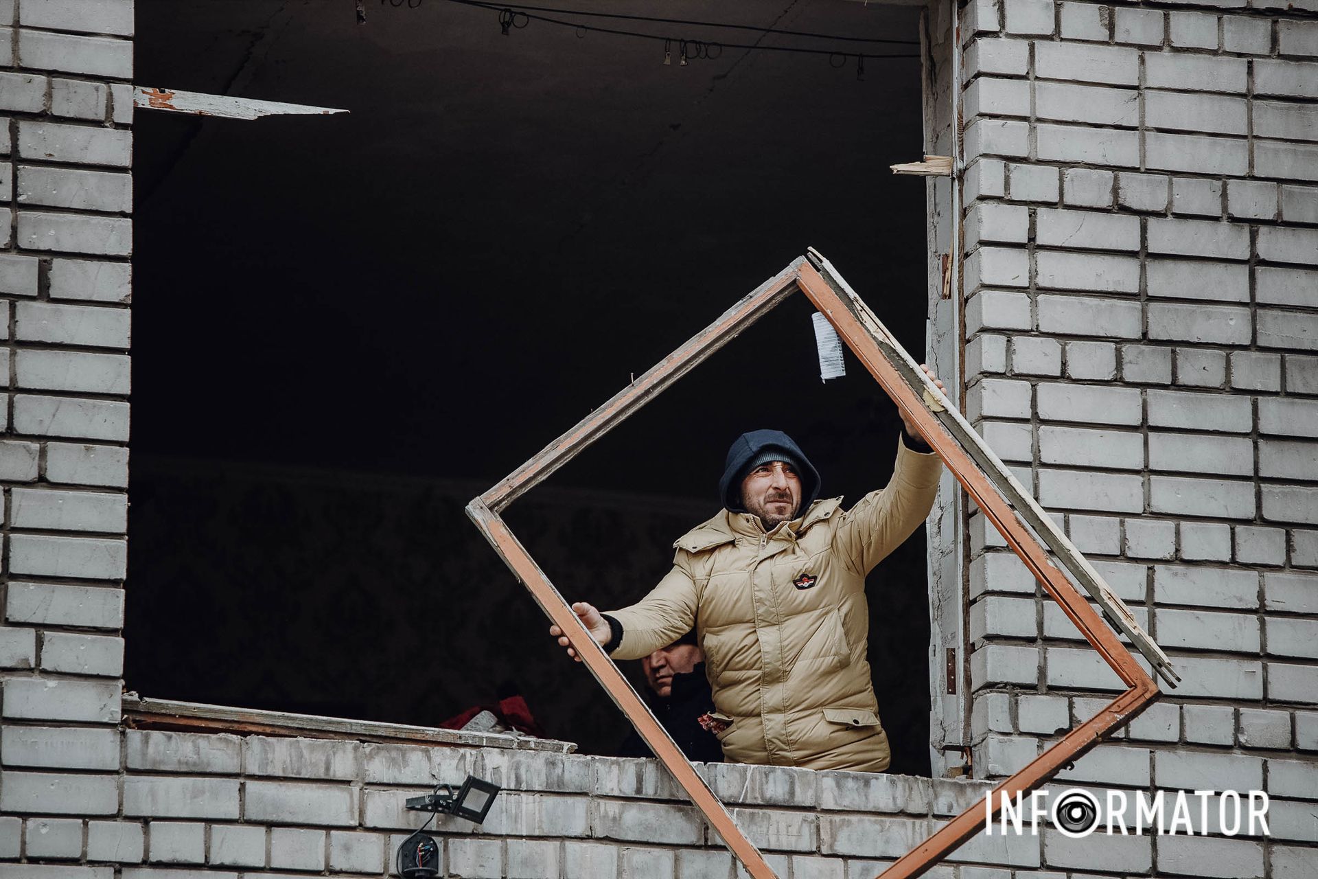 Люди прибирають вибиті шибки