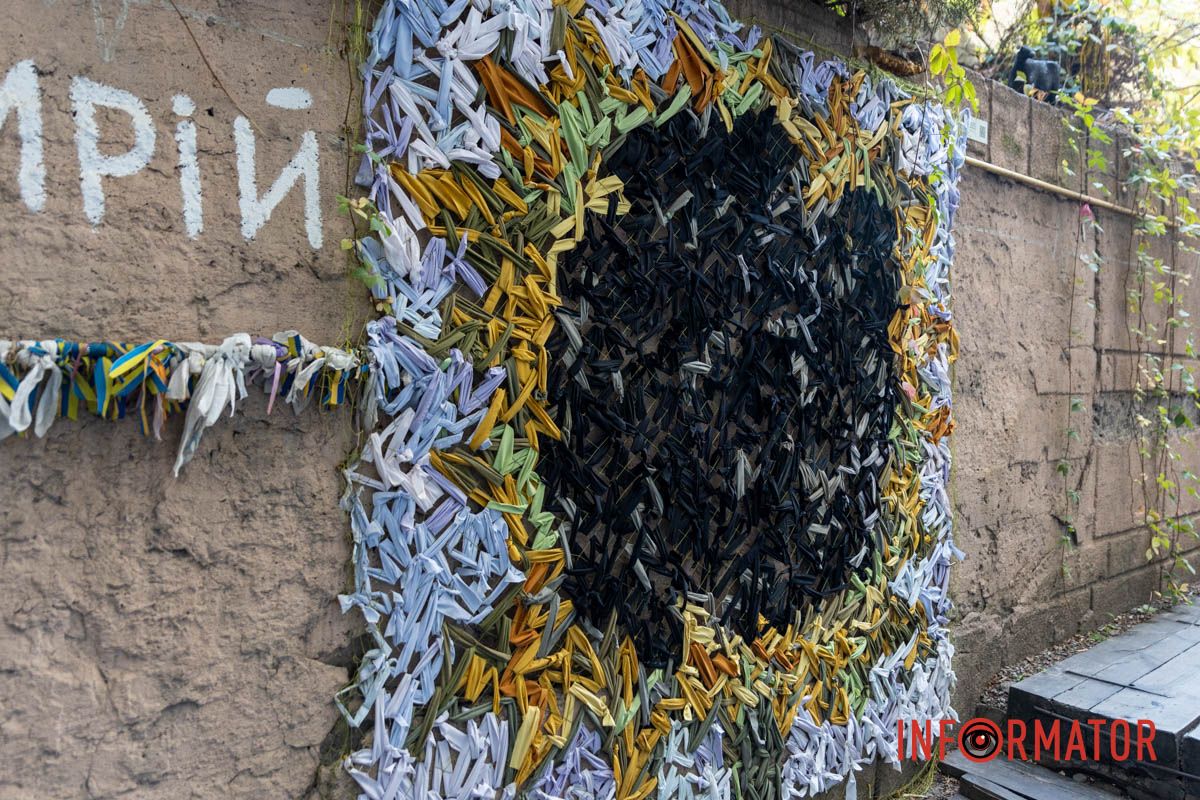 Маскувальна сітка, яка зазвичай слугує для приховування, у цій роботі трансформується в артоб'єкт, що привертає увагу Маскувальна сітка, яка зазвичай слугує для приховування, у цій роботі трансформується в артоб'єкт, що привертає увагу