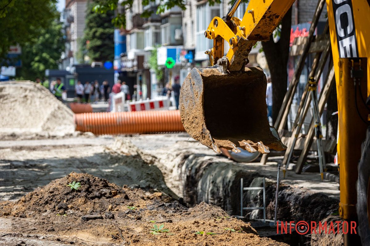 Копають яму будівельною технікою У Дніпрі на Незалежності через ремонт каналізації частково перекритий тротуар 9
