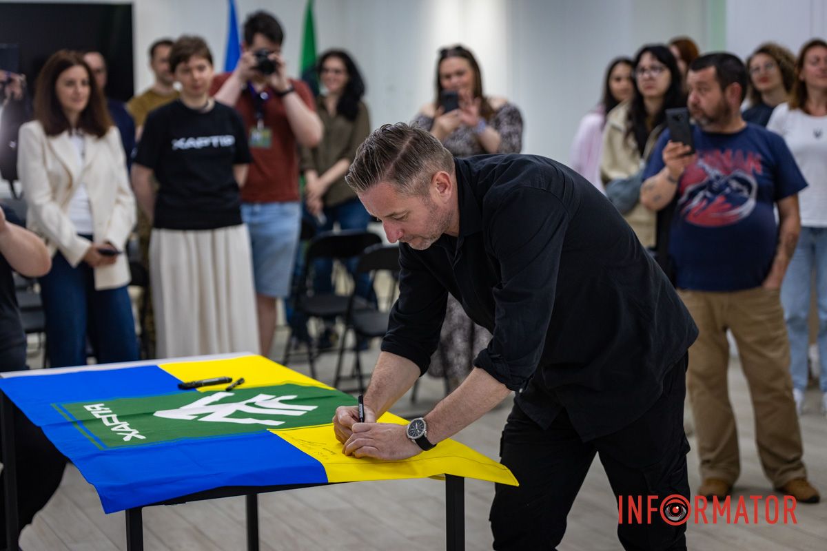 Сергей Жадан расписывается на флаге бригады В Днепре на Баррикадной открылся "Хартия-Хаб" 13-й бригады НГУ 12