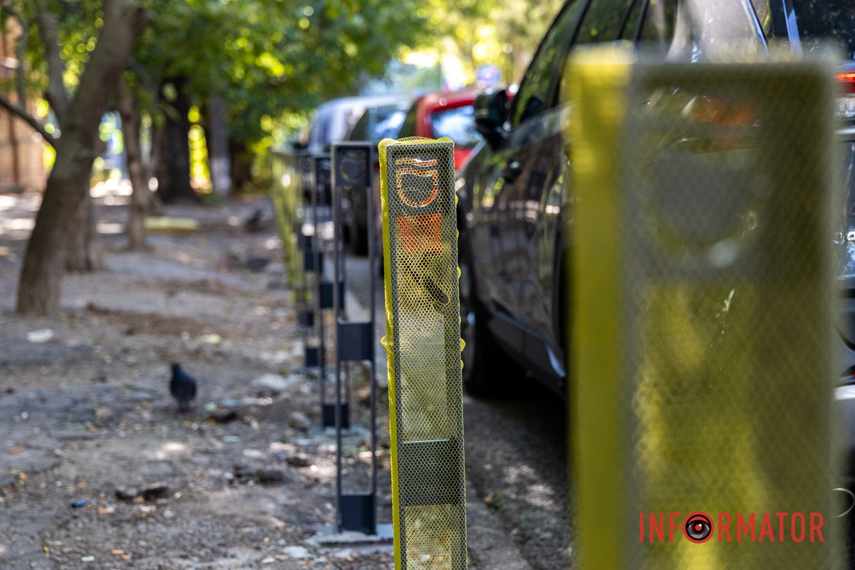 На фоне разбитого тротуара и голубя Парковочный беспредел: в Днепре на Ивана Акинфиева появились паркомат и антипарковые столбики 10