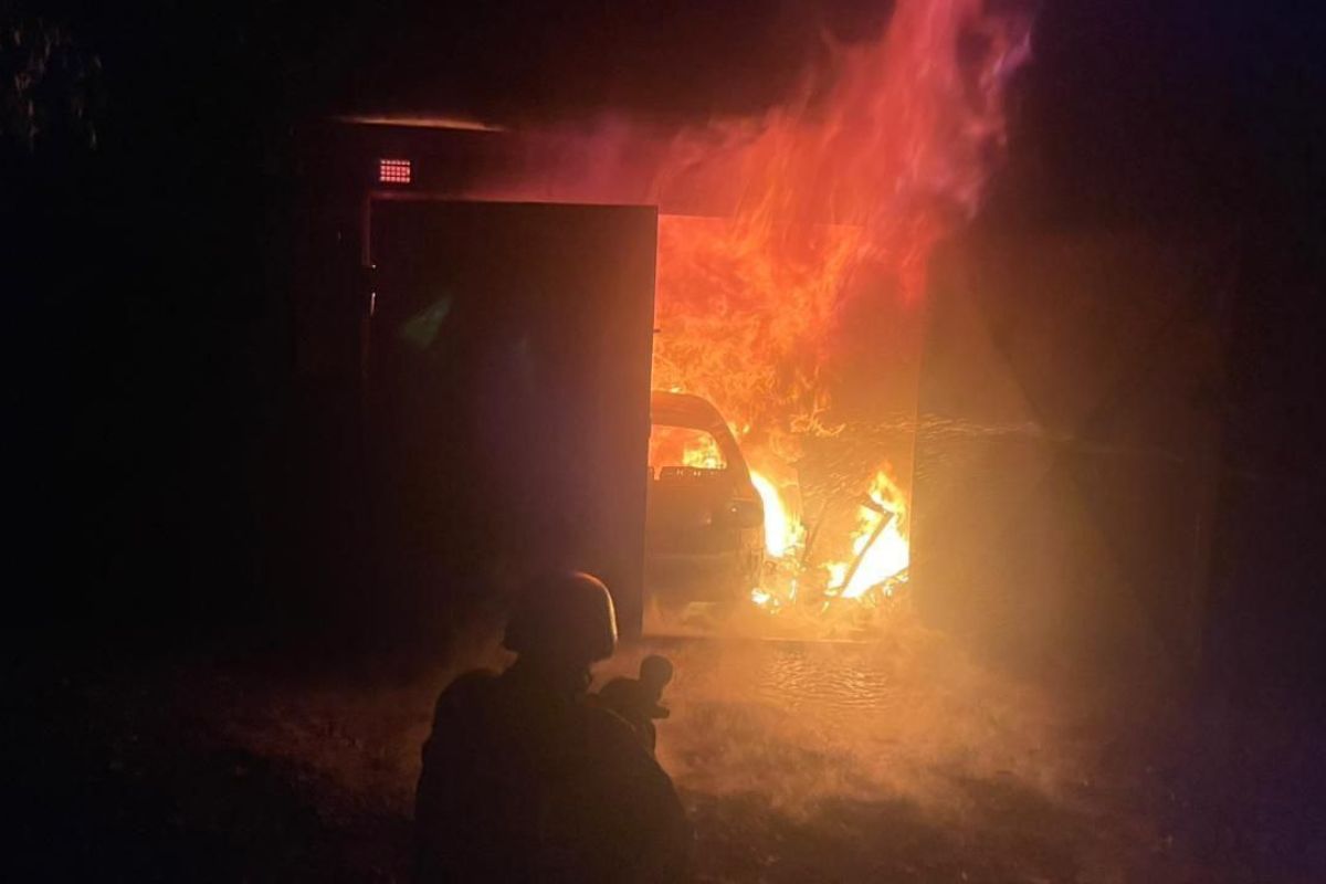 Палаюче авто в гаражі Палаюче авто в гаражі