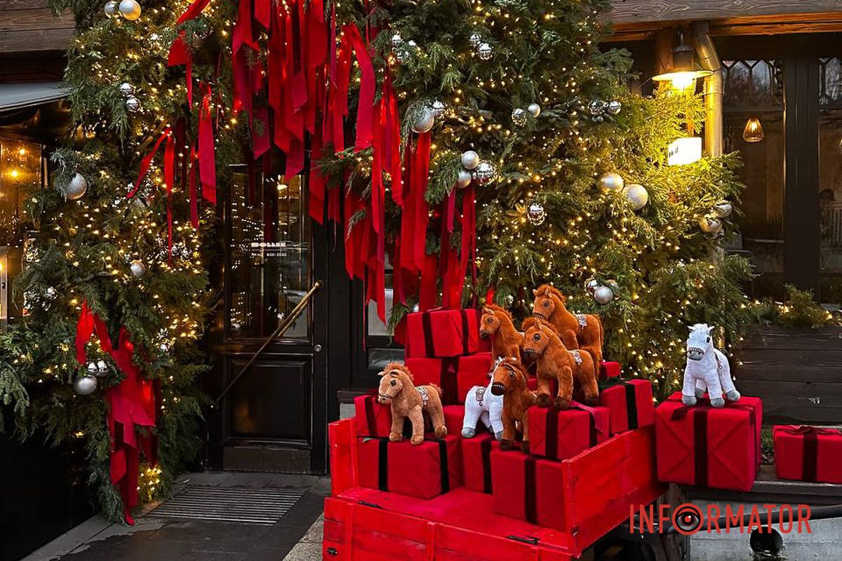 Рядом — яркие красные подарки и декоративная тележка с игрушечными конями. Рядом — яркие красные подарки и декоративная тележка с игрушечными конями.