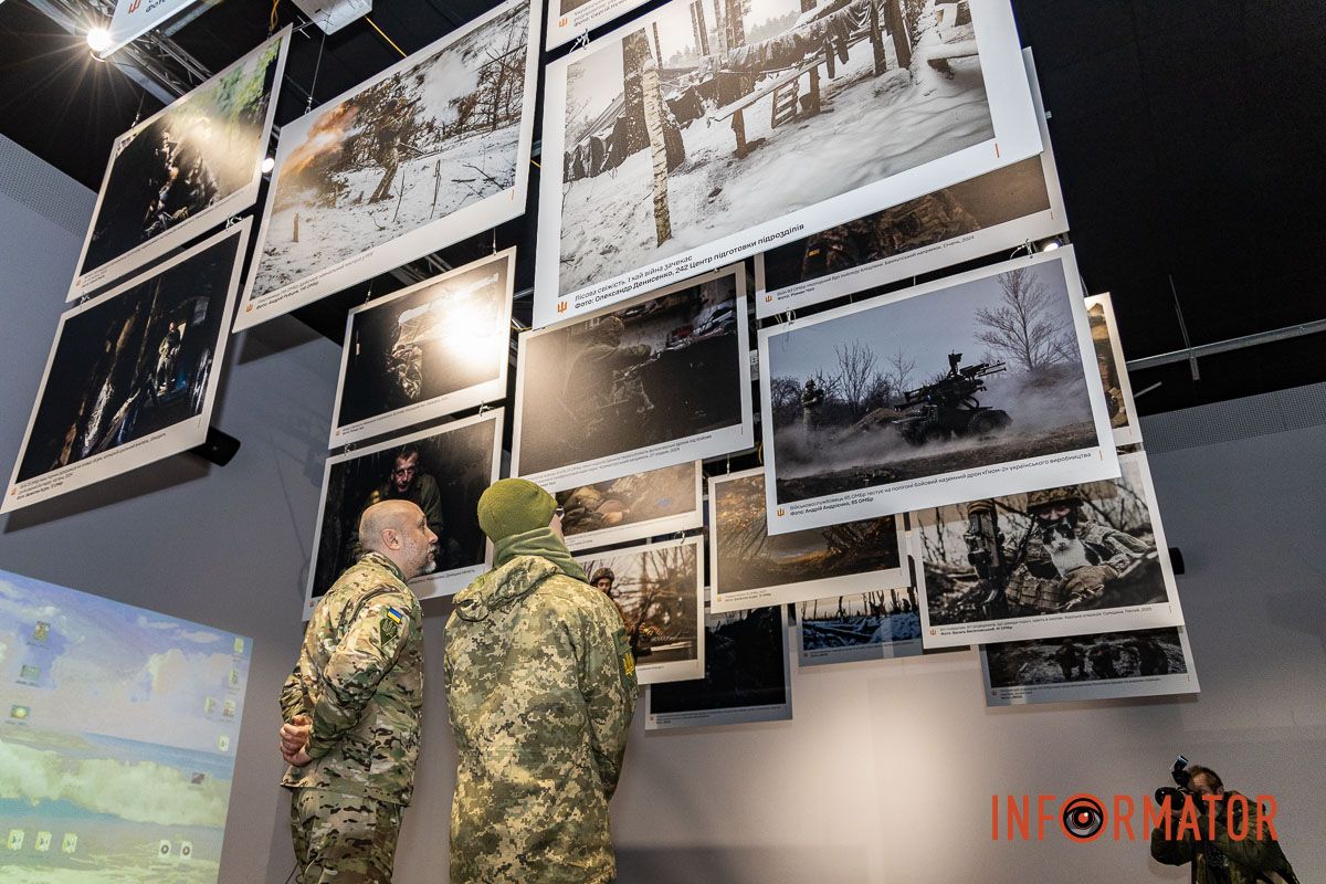 Відвідувачі уважно розглядають світлини «Народ, що став військом»: у Дніпрі відкрили фотовиставку до роковини повномасштабного вторгнення 14