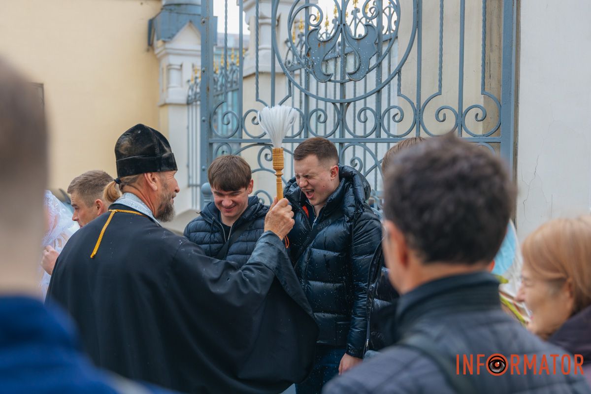 Священник окроплює вірян біля стін кафедрального собору
