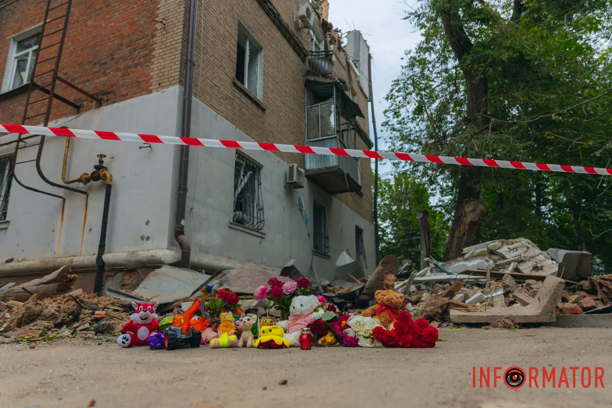 Біля чотирьохповерхового будинку містяни залишають квіти, дитячі іграшки та лампадки на згадку про загиблих