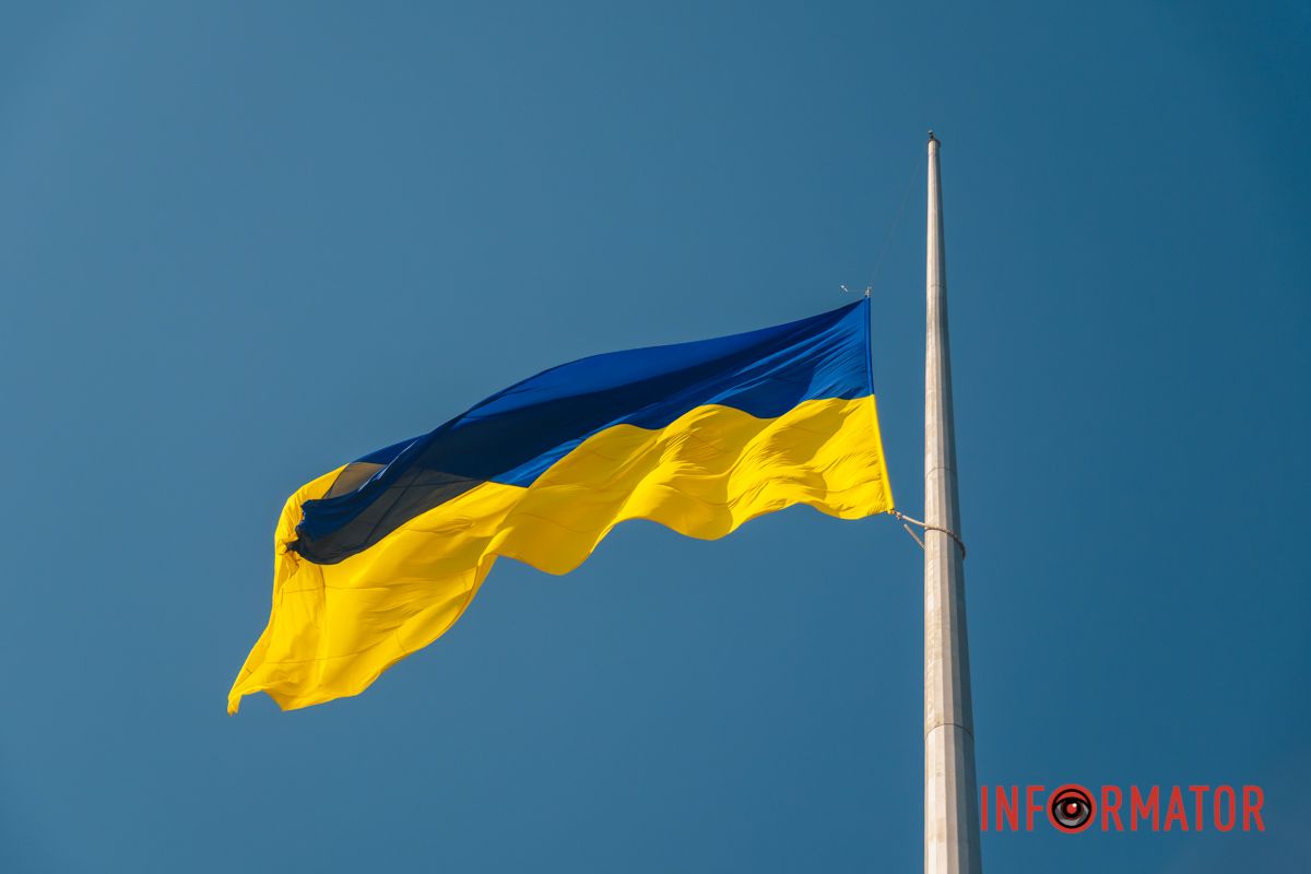 Високі флагштоки та фасади міських установ прикрасили величні прапори, які розгортаються на вітрі проти синього серпневого неба