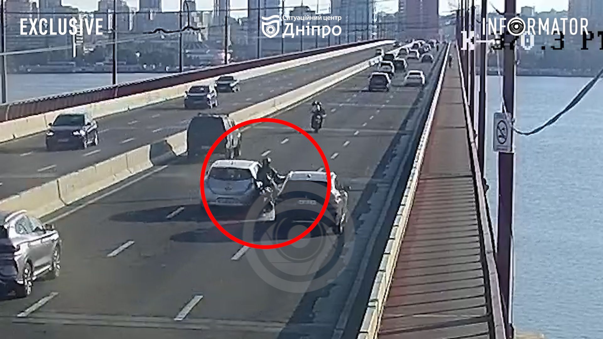Намагався проїхати між двох авто: у Дніпрі на Новому мосту мотоцикліст впав під Nissan Leaf, відео моменту