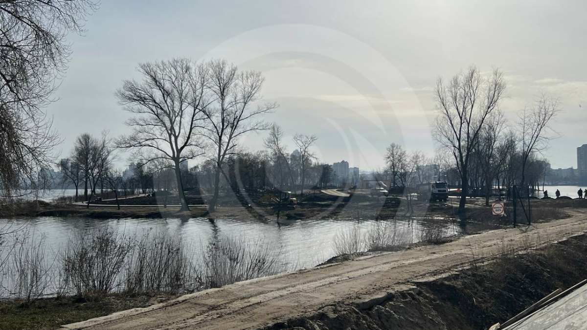 На острові працює важка техніка - бульдозери та трактори, які проїздять туди вузькою греблею поряд з містком