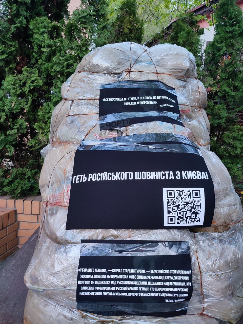 К памятнику прикреплены три черные бумажки, одна из них - с QR-кодом, ведущим на раздел петиций на сайте КГГА