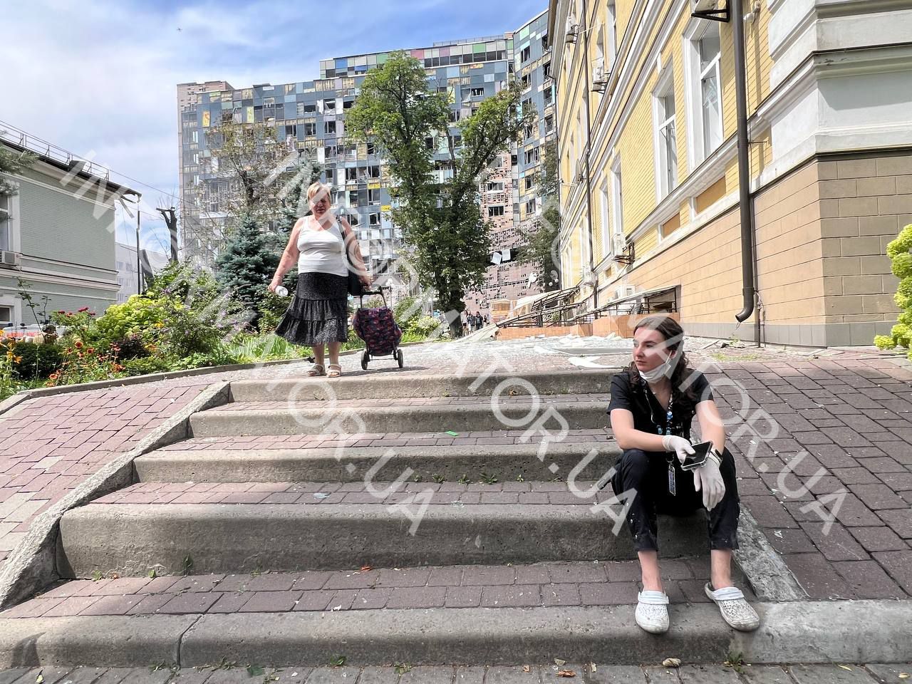 Жінка на сходах лікарні після удару РФ по Охматдиту 7 липня. Фото - Інформатор