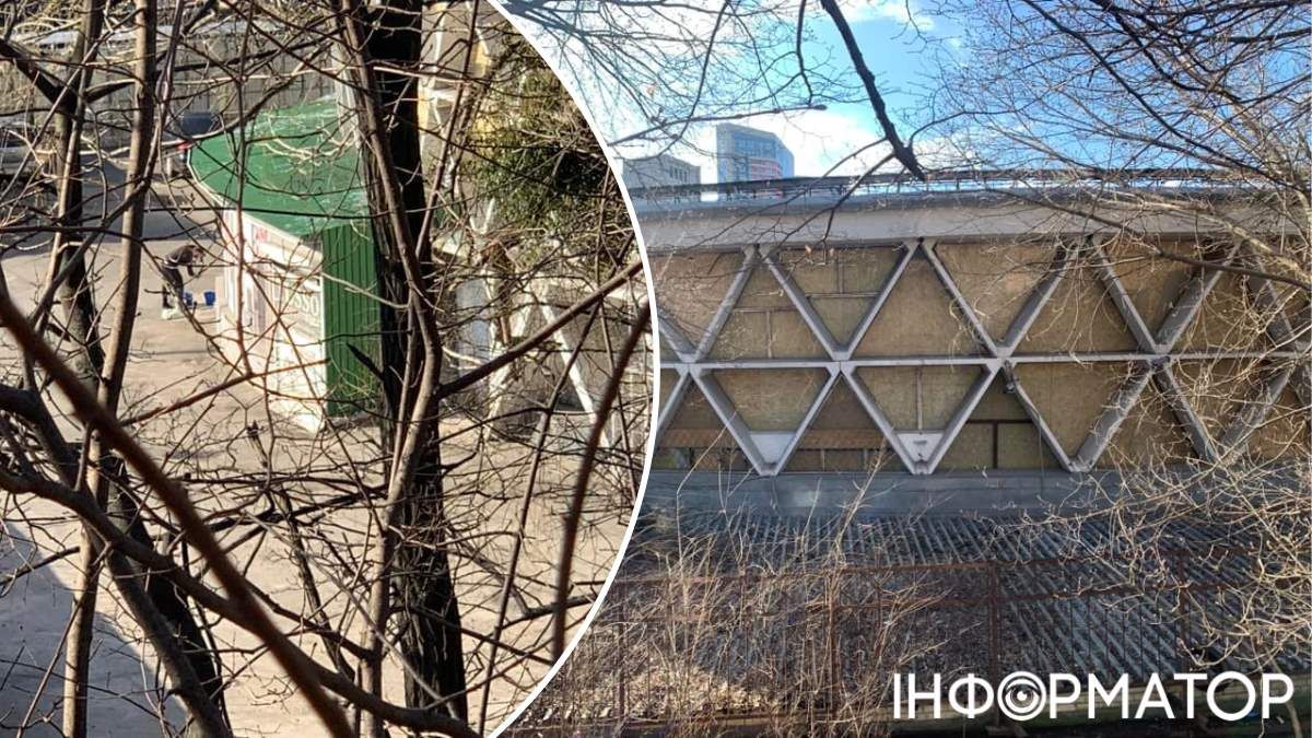 Окна треугольной формы забиты OSB-панелями, а внутри огороженной территории находятся строители. Фото: Дмитрий Перов