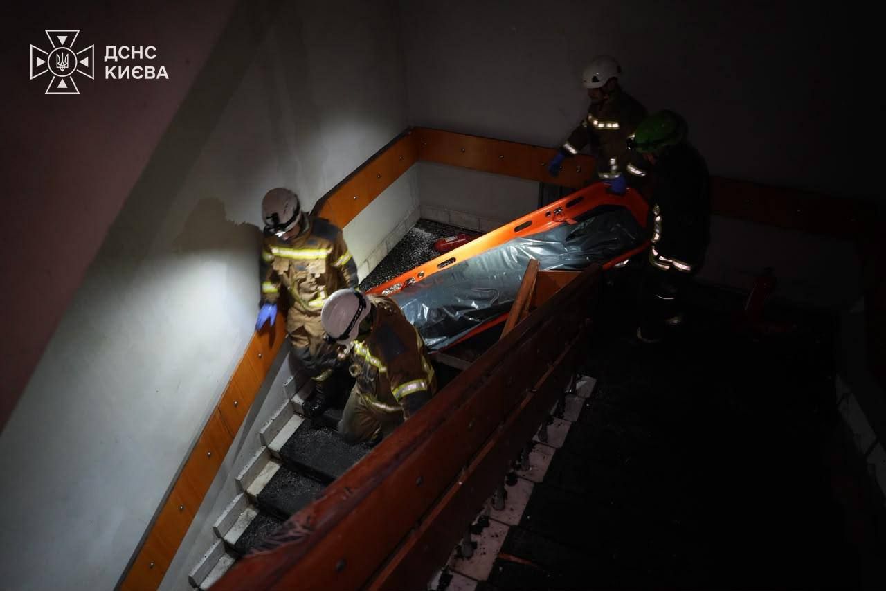 Рятувальники виносять тіло загиблої особи внаслідок атаки по НАН України