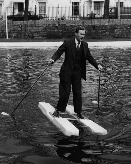 На чорно-білому фото винахідник Халтон демонструє свої морські черевики та гребні гвинти на каналі Гранд Юніон. 