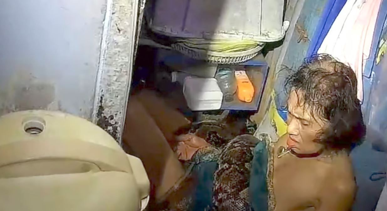 Пітон обвивається навколо тулуба Аром Арунро на підлозі її кухні в Таїланді.