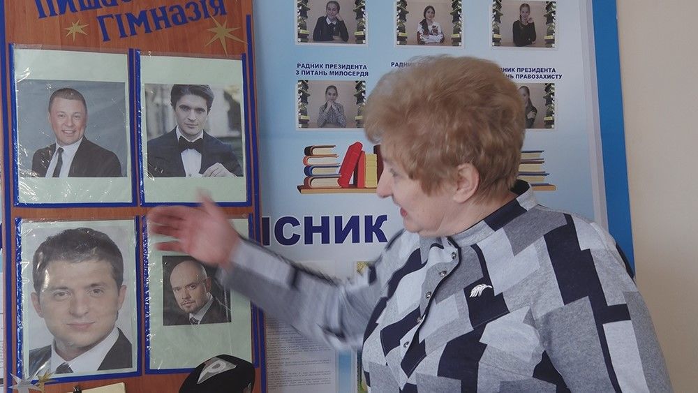 На фото директор Алла Шепилко возле стенда с лучшими выпускниками гимназии №95