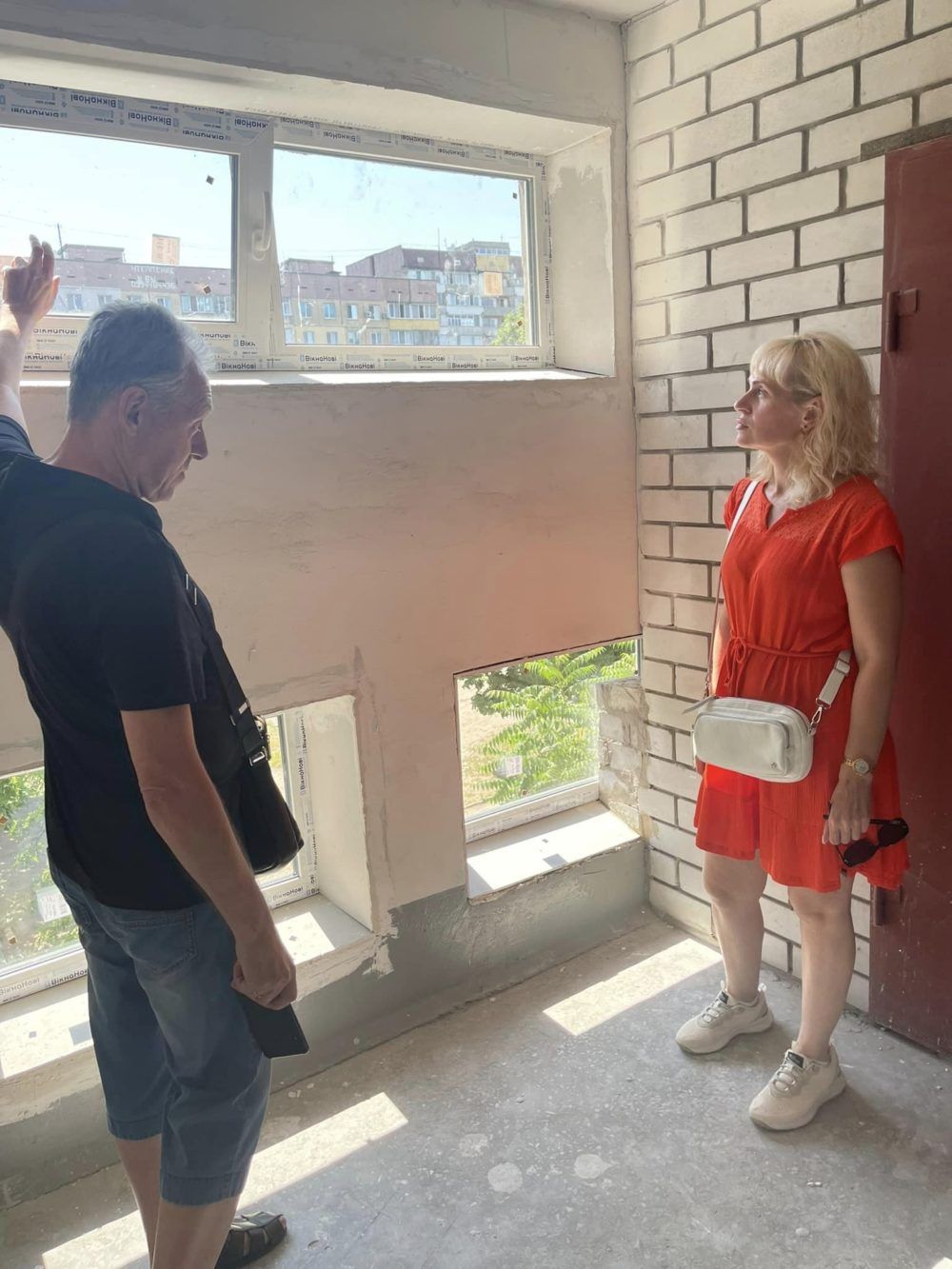 Депутатка Олена Іонесян оглядає нові вікна у житловому будинку. Фото: фейсбук депутатки