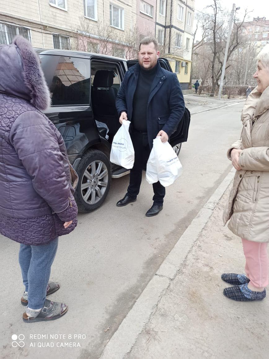 Депутат Микола Чорний роздає людям набори з продуктами