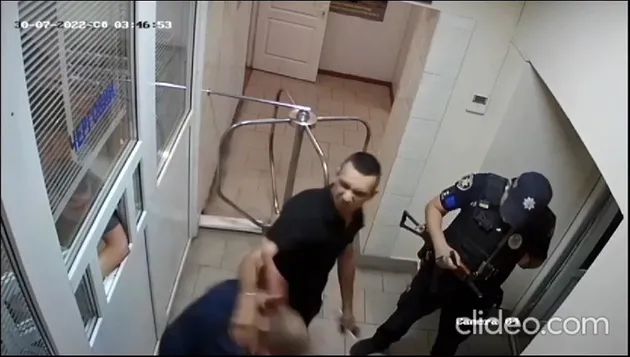 Цивільний у чорному б'є затриманого по голові Цивільний у чорному б'є затриманого по голові