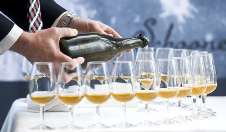 Мужчина наливает воду из бутылки Veuve Clicquot Мужчина наливает воду из бутылки Veuve Clicquot