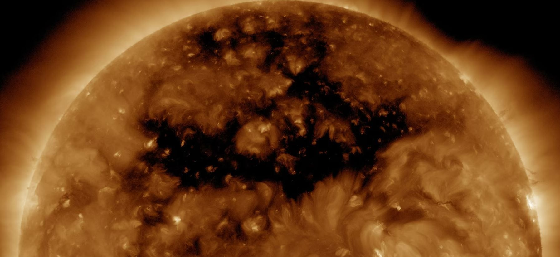 Бронзове кольорове зображення сонця з дірою, звідки потік частинок потрапляв на полюси Землі.  