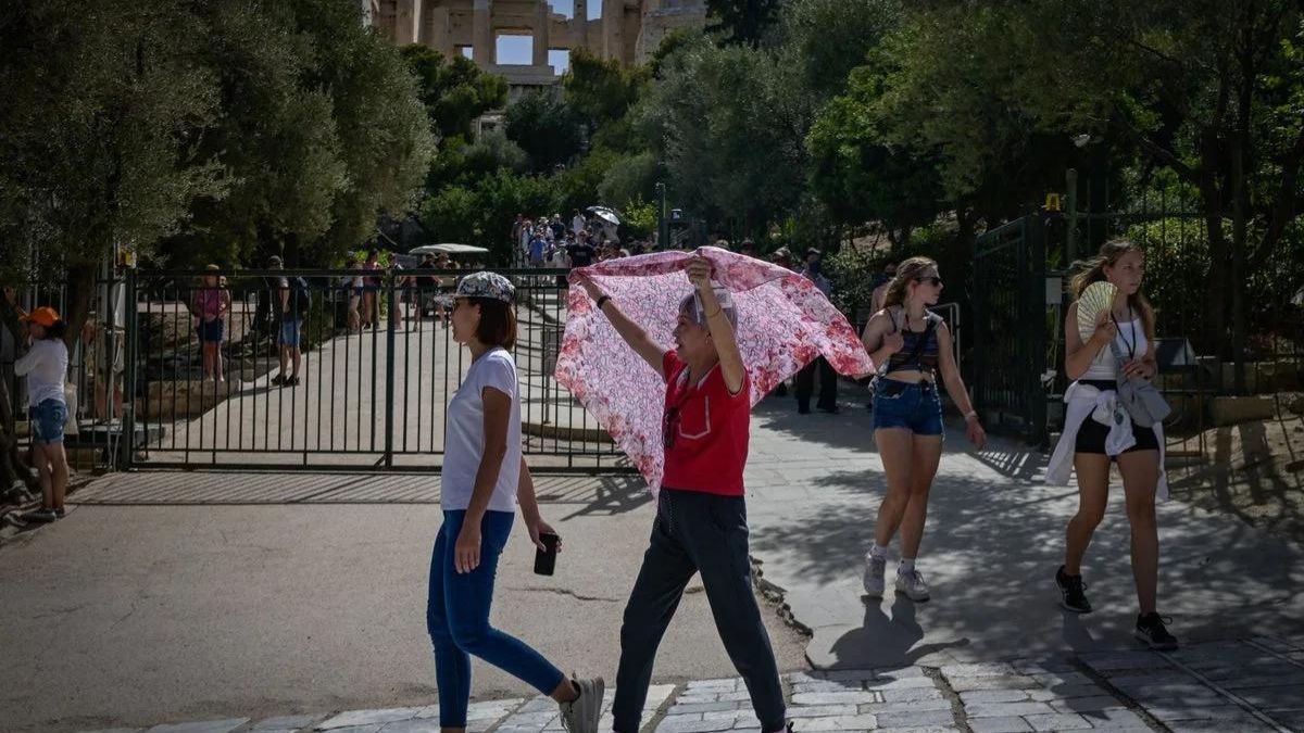 Туристи в жахливу спеку в Афінах . Aото: AFP через Getty Images Туристи в жахливу спеку в Афінах . Aото: AFP через Getty Images