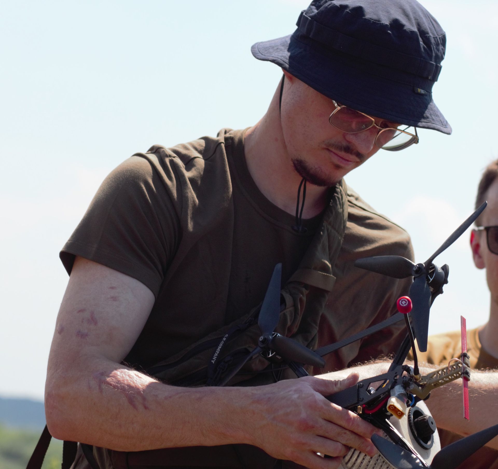 Інженер споряджає дрон батареєю та вантажем Інженер споряджає дрон батареєю та вантажем