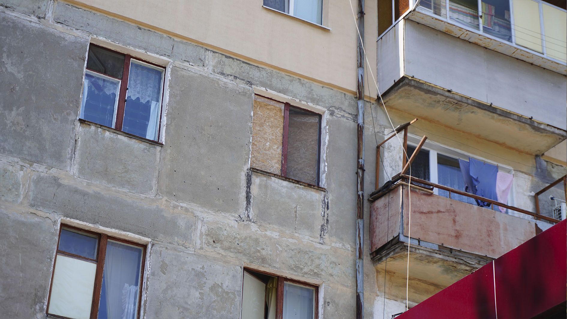 Закрите фанерою вікно в будинку, розташованому біля місця прильоту Закрите фанерою вікно в будинку, розташованому біля місця прильоту