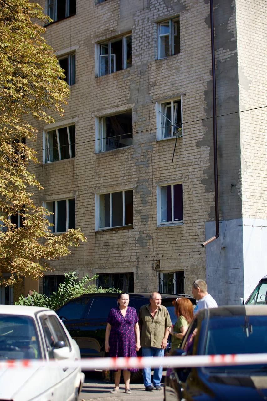 Люди собираются у изуродованного дома Люди собираются у изуродованного дома