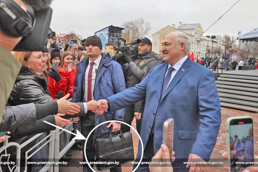 Лукашенко "зцілює" жінку, а його охоронець тримає цікаву валізу Лукашенко "зцілює" жінку, а його охоронець тримає цікаву валізу